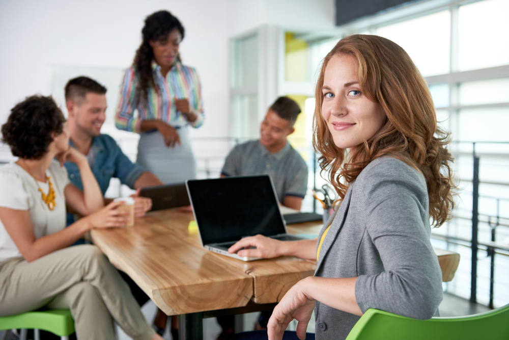 Image of a successful casual business woman using laptop during meeting